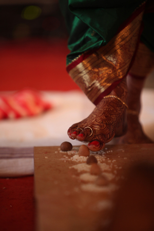 The last steps of the bride among the 7 taken during a traditional hindu religious wedding consisting of a betelnut and rice.の写真素材