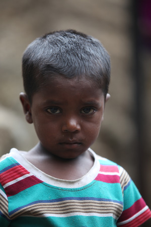A portrait of a poor Indian boy looking with a sad face.