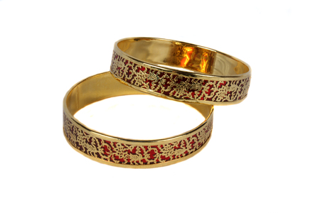 Traditional Indian bangles with an intricate design in gold on crimson color.の写真素材