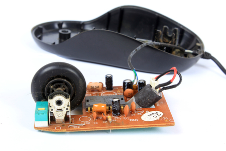An old mouse with a wheel opened to show the technology used in it.の写真素材