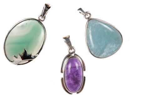 Beautiful silver pendants made from different semiprecious gemstones, on white studio background.の写真素材