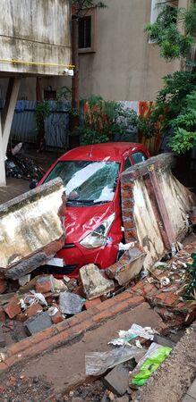 A car destroyed by a wall during floods in India, during the monsoons.の写真素材
