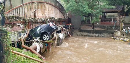 A car which got carried with floods water stuck in a bridge in India.の写真素材