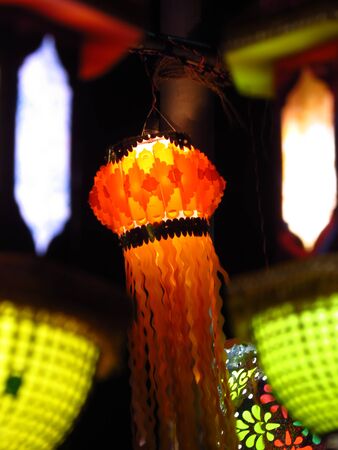 An orange traditional Diwali lantern hanging on an old pole during Diwali festival in India.の写真素材