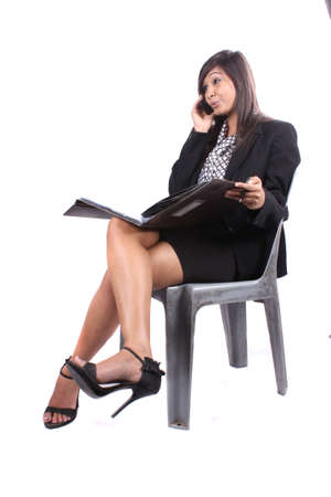 A young beautiful Indian businesswoman on phone, on whiteの写真素材