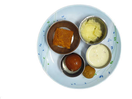 Five different Indian Sweets like barfi, laddoo, shrikhand, kheer and gulab jamun served in a plate.の写真素材