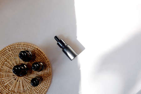 Black dropper bottle with pipette. Cosmetic oil bottle mockup. Cosmetic product concept.