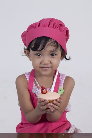 little girl holding a cupcakeの写真素材