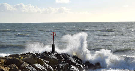Waves crashing against the breakwater at Hengistbury Head, Dorsetの写真素材