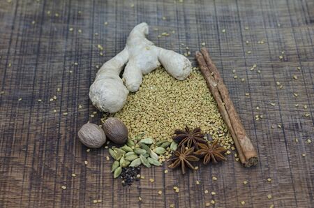 A selection of spices used in an ayurveda diet and healing, with root ginger, a cinnamon stick,...