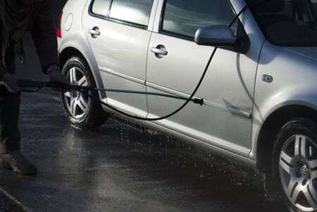 man washing silver car at jet washの写真素材
