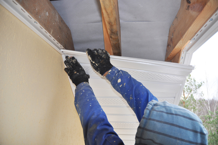 Contractor, Roofer Installing Soffit. Roofing Construction. Soffit and Fascia Installation.の写真素材