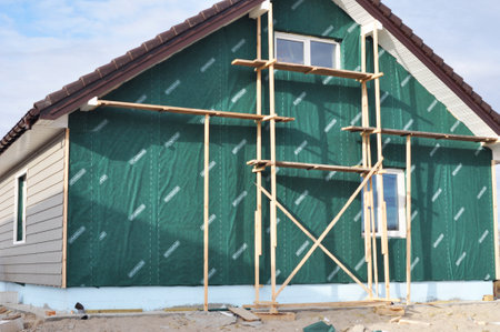KIEV, UKRAINE - MAY, 16, 2017: Building, Repair, Remodeling House with Plastic Siding and Insulation Membrane, Mineral Wool.Foundation insulation with styrofoam. Installing Rigid Foam Insulation.のeditorial素材