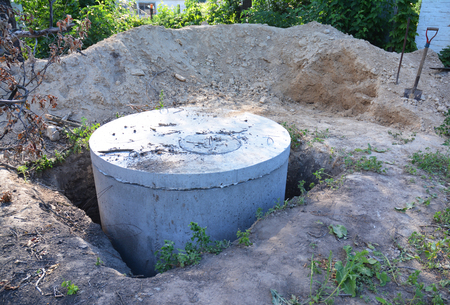 Manhole cover installation with sewer tank outdoors.の写真素材