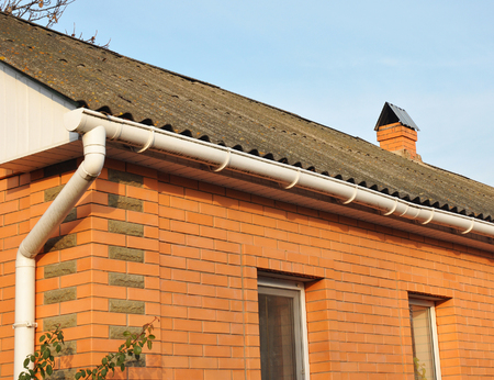 Closeup of problem connections areas for rain gutter waterproofing with asbestos roof.