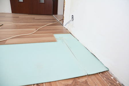 Installing wooden laminate flooring with insulation and soundproofing sheets.の写真素材