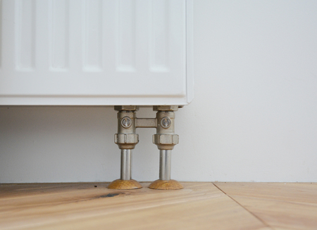 Radiator pipe covers sleeves. Install radiator for heating system with hiding pipes in the wooden...