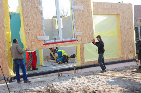 KYIV, UKRAINE - July, 10, 2018: 
Contractors installing modular frame plywood board panel walls house on the home construction site. Structural insulated panels house installation.のeditorial素材