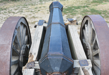 Old rusty cannon or artillery gun on wheels as new cold war concept.