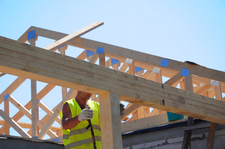 KYIV, UKRAINE - December, 27, 2018: Roofer contractor building house roof beams, trusses, wooden frame beams on rooftop.のeditorial素材