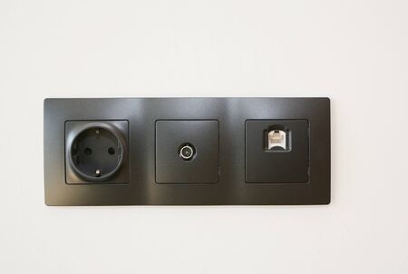 Black outlet plug, tv cable on the wall. Socket and European Power in the New Flat.