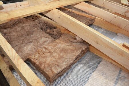 Attic Roof Insulation. Close up on insulation layers of mineral wool insulation, house roof insulation. Insulating with Mineral Rock Wool House Attic Roof.の写真素材