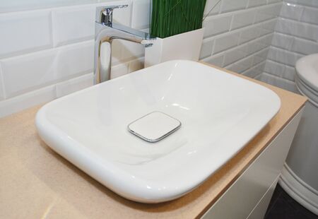 Bathroom interior with tiled walls and whie ceramic sinkの写真素材