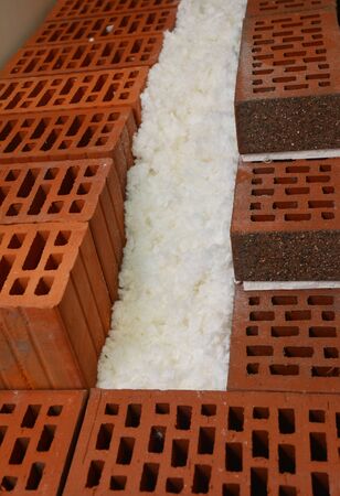 Close up on foam insulation in house brick and ceramic block wall