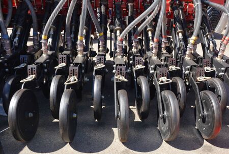 A close-up on tractor mounted multi row corn planter, seeder and fertilizer seed planter.