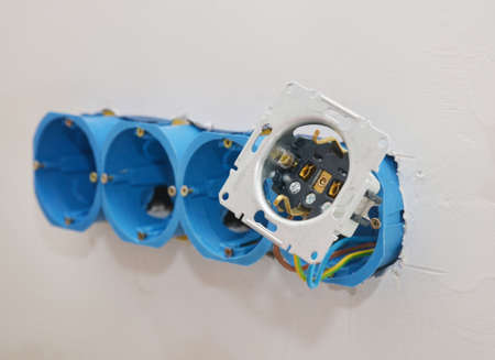Installing of a new multiple socket electrical outlet connecting the wires to the device.