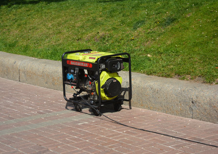 KYIV, UKRAINE - MAY, 17, 2020: Outdoor power equipment, a portable gasoline generator working outdoors. Portable generator safety tips while using it in the street.のeditorial素材
