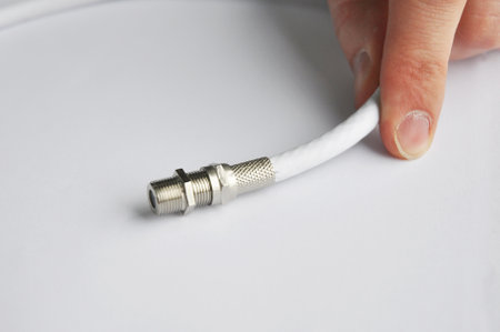 Close up on white TV cable connector.
