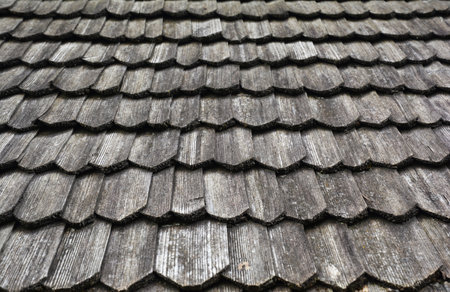 Gray wooden roof tiles background, texture. A close-up of an old gray roof covered with wooden tiles.の写真素材