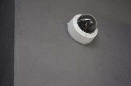 Close up on security CCTV camera is mounted on the room wall.
