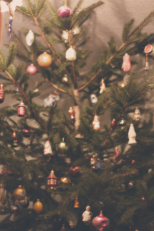 A close up of an old fashion, vintage, nostalgic Christmas tree. A rustic country Christmas tree with beautiful glass Christmas animal ornaments, baubles, and festive balls.の写真素材