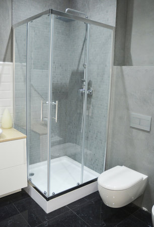 Luxury Modern Bathroom with black marble tiles floor, toilet and shower cabin with glass wall.の写真素材