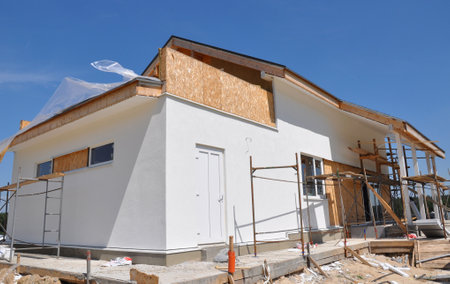 Modern house construction site with plastering walls, scaffolding exteriorの写真素材