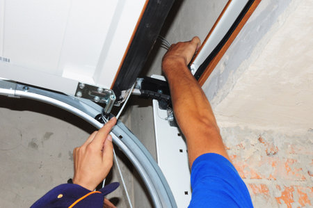 Contractor repair and install garage door. opener Replace, Repair a Broken Garage Door Spring.の写真素材