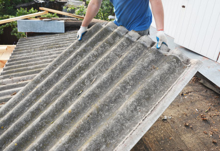 Asbestos roof removal. Asbestos removal and roof renovation. Roofer remove old asbestos cement sheet.の写真素材