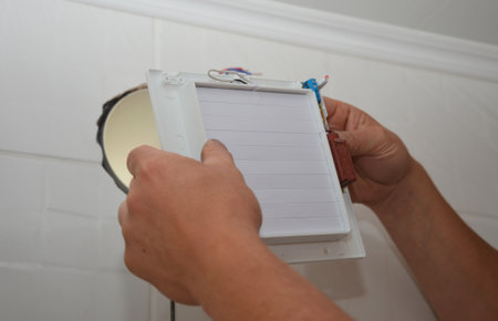 Installing electric exhaust fan in bathroom wall ventilation systemの写真素材