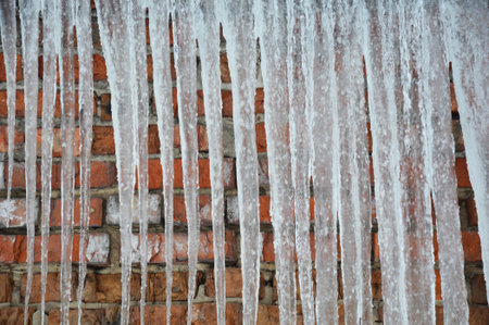 Icicles texture background in cold frosty winter day. Ice dam concept.の写真素材