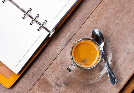 blank notebook coffee cup on wooden backgroundの写真素材