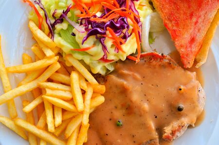 grilled steak, french fries, toast and saladの写真素材