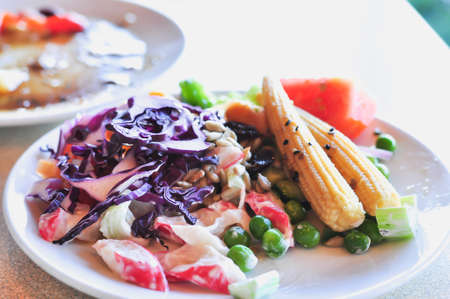 fresh vegetable salad on white disc, close-up