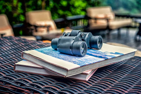 binoculars with the book on Rattan table