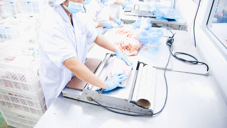 Butcher wrapping pork in meat industry