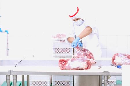 butcher that cuts fresh pork in meat industryの写真素材