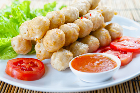 fried meat ball and vegetable on white dishの写真素材