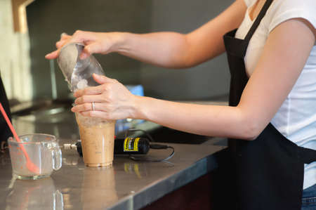asia beautiful female bartender makes iced coffee on cafeの写真素材