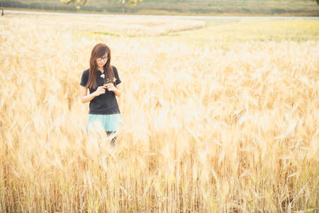 portrait of a beautiful glasses woman in barley fieldの写真素材
